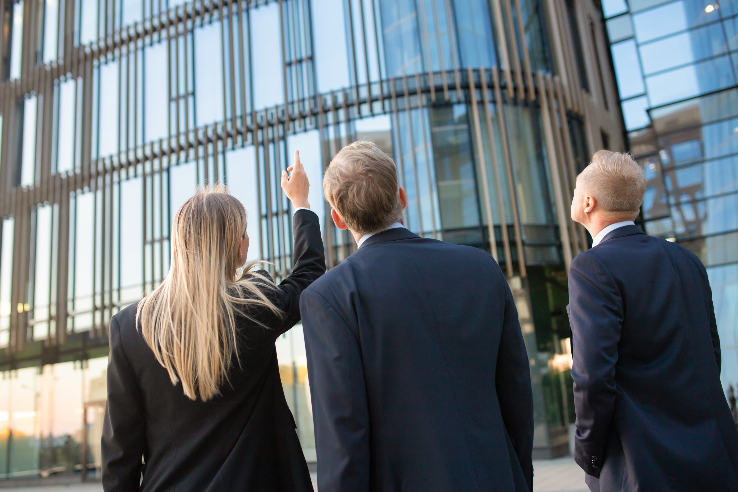 Business professionals in suits looking at office building
